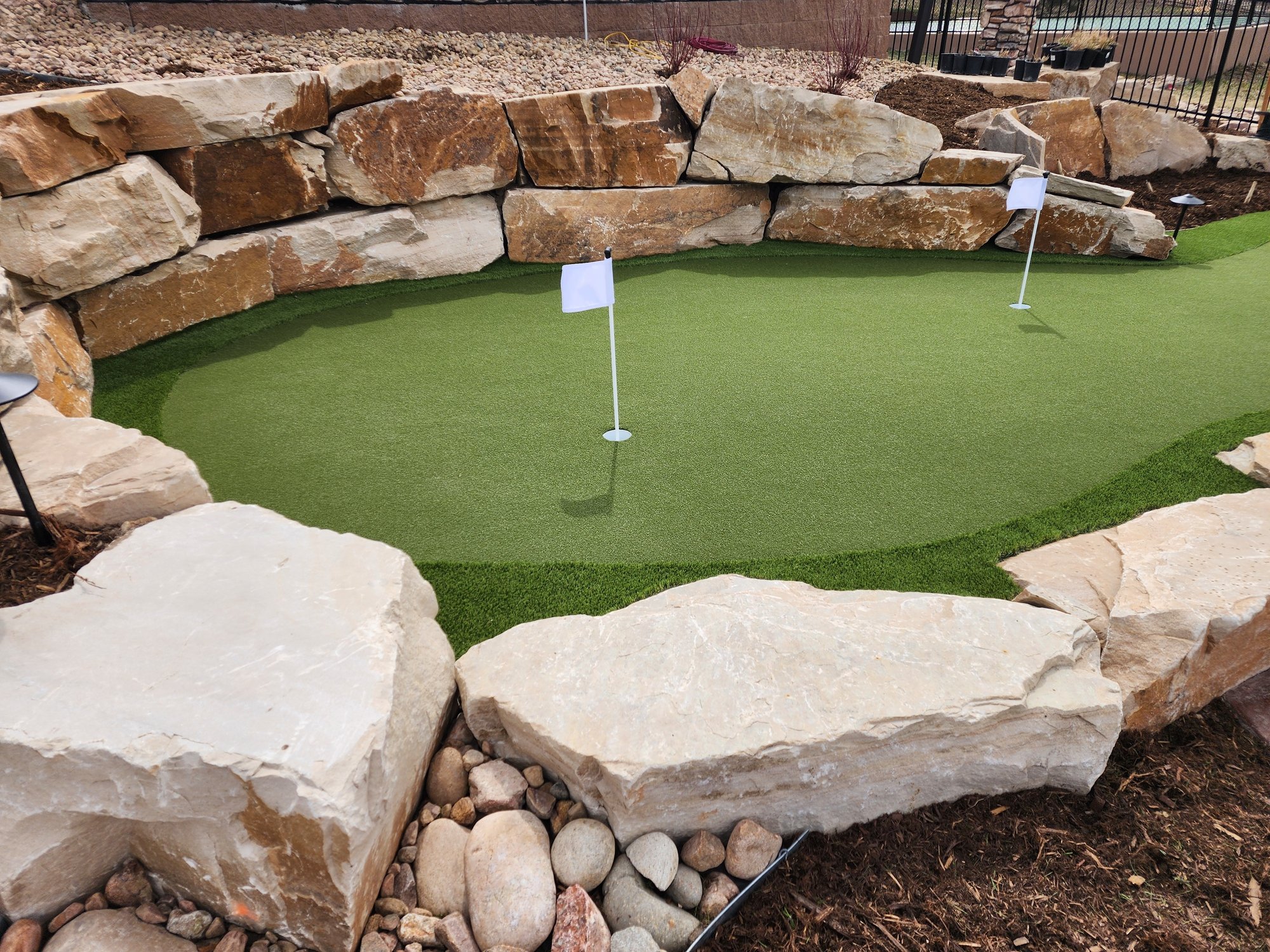 Putting green with fringe border and natural stone walls